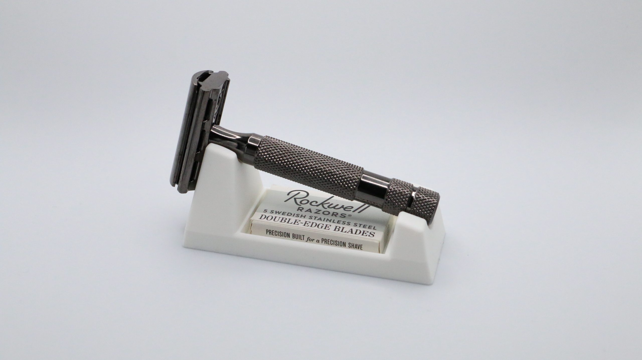 The ivory rest and its razor photographed small and centred on a white sweep, showing the low profile of the wedge from a distance.